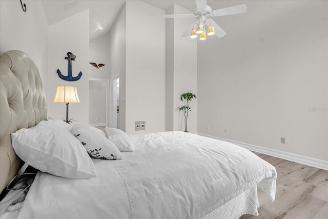 bedroom with light hardwood / wood-style flooring, high vaulted ceiling, and ceiling fan