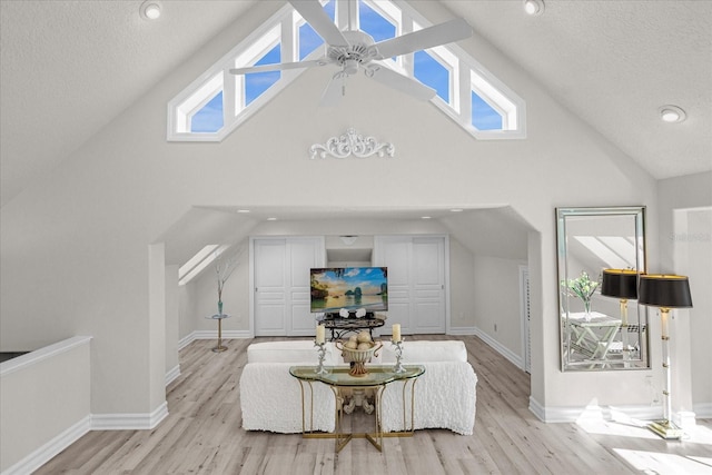 17601 Sawgrass Run, Tavares, FL 32778 - living area with high vaulted ceiling, light wood finished floors, a ceiling fan, healthy amount of natural light, and baseboards
