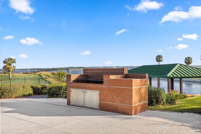 exterior space with a water view and exterior kitchen