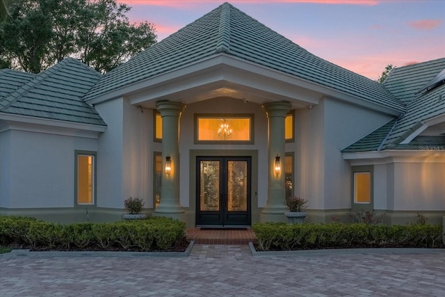 exterior entry at dusk featuring french doors