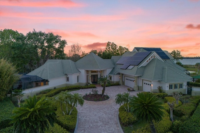 view of front of property featuring a garage and solar panels