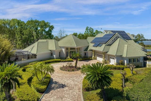 back of house with solar panels and a garage