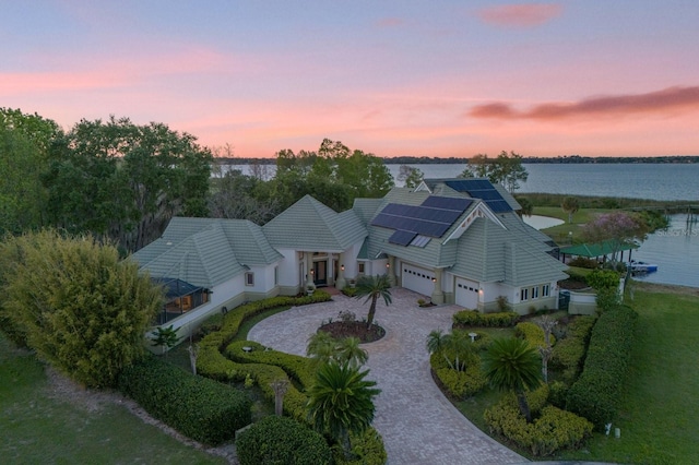 aerial view at dusk featuring a water view