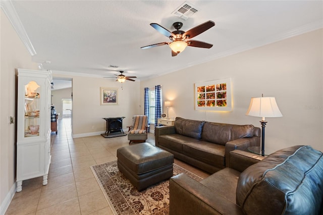 living area featuring a healthy amount of sunlight, light tile patterned flooring, visible vents, and ornamental molding