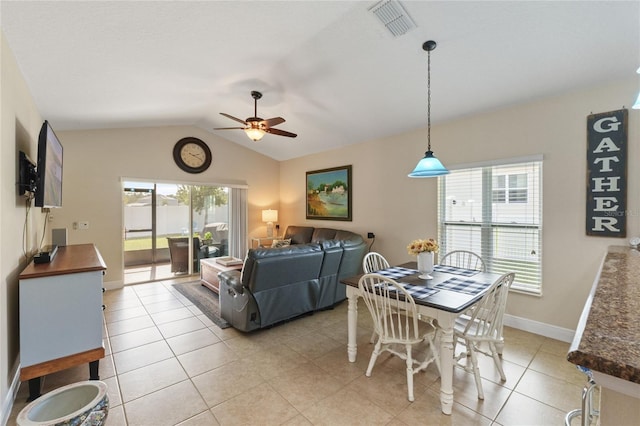 dining space with plenty of natural light, visible vents, vaulted ceiling, and light tile patterned floors