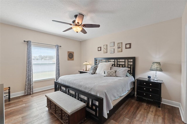 bedroom with a textured ceiling, baseboards, and wood finished floors