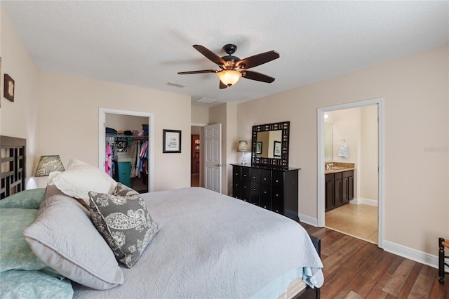 bedroom featuring baseboards, visible vents, wood finished floors, a spacious closet, and a closet