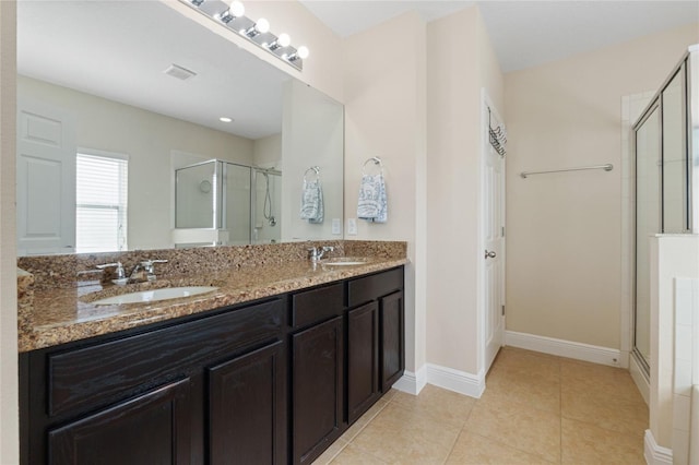 bathroom with double vanity, tile patterned flooring, a sink, and a shower stall