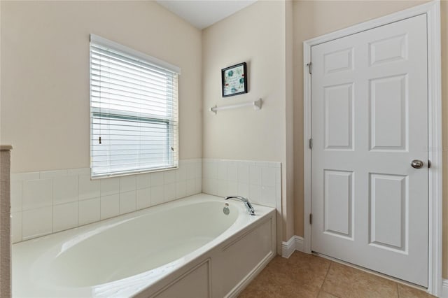 bathroom with a garden tub and tile patterned flooring