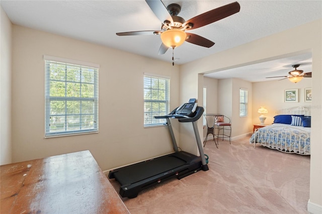 carpeted bedroom with multiple windows, ceiling fan, and baseboards