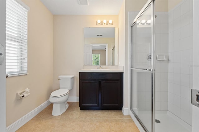 bathroom featuring toilet, vanity, a shower stall, baseboards, and tile patterned floors