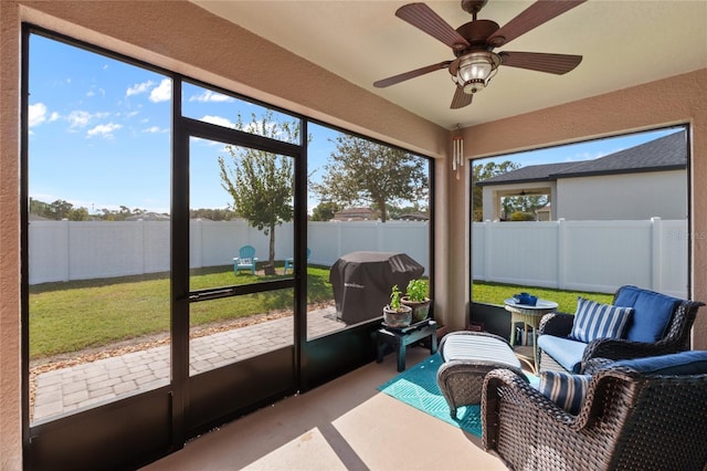 sunroom / solarium featuring a ceiling fan