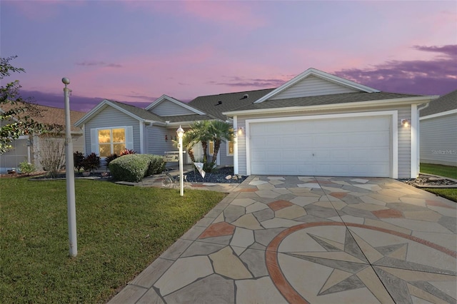 ranch-style house with a garage and a lawn