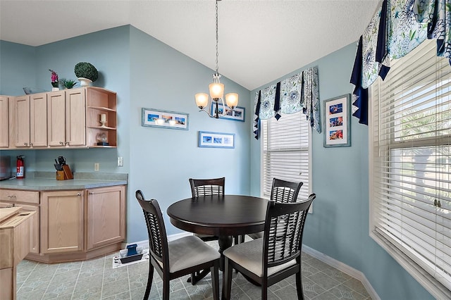 dining space with light tile patterned floors, vaulted ceiling, and an inviting chandelier