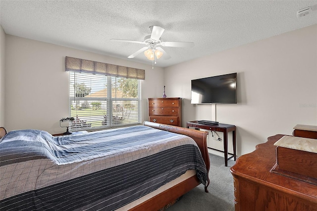 bedroom featuring a textured ceiling, carpet floors, and ceiling fan