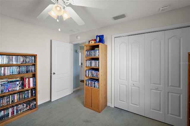 interior space with carpet floors, a textured ceiling, and ceiling fan