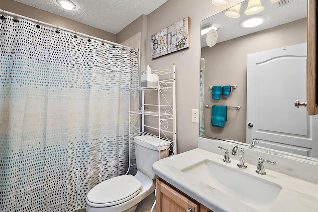 bathroom with vanity, a textured ceiling, toilet, and walk in shower