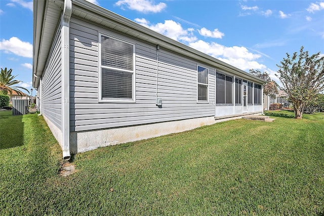 view of home's exterior featuring a yard, cooling unit, and a sunroom