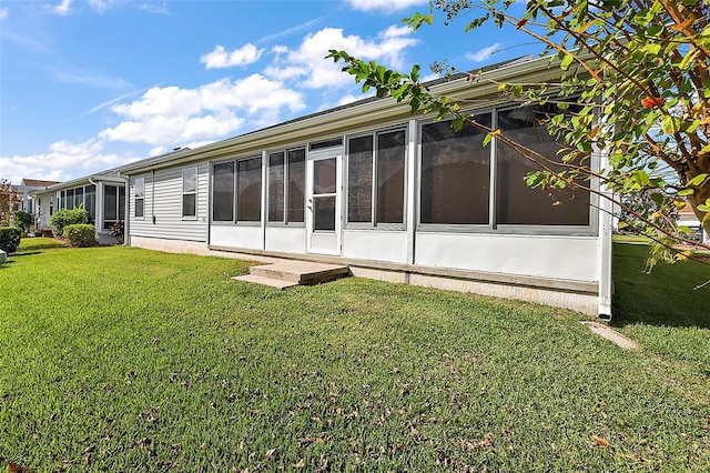 back of property featuring a yard and a sunroom