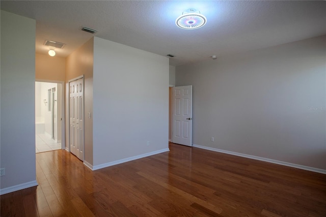 spare room with hardwood / wood-style floors and a textured ceiling