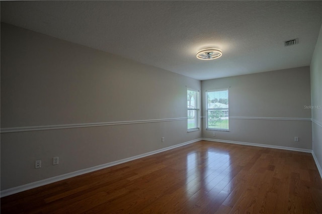 empty room with a textured ceiling and hardwood / wood-style floors