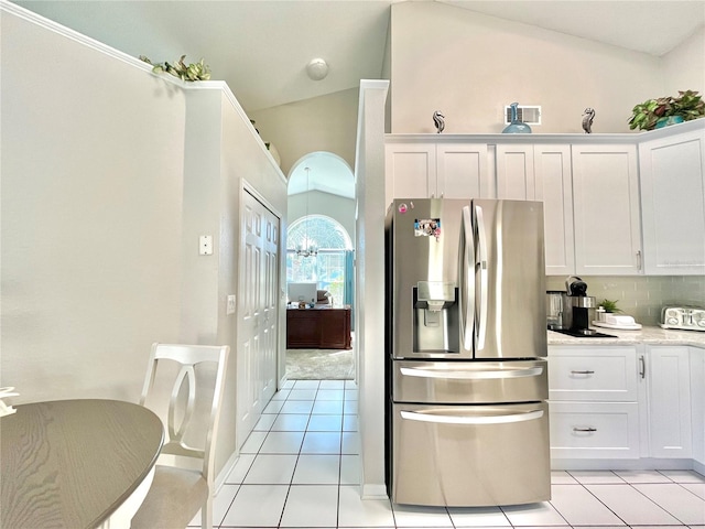 kitchen featuring tasteful backsplash, light tile patterned floors, stainless steel fridge with ice dispenser, white cabinetry, and high vaulted ceiling