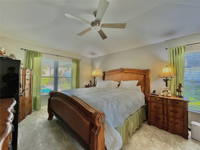 carpeted bedroom with ceiling fan and multiple windows