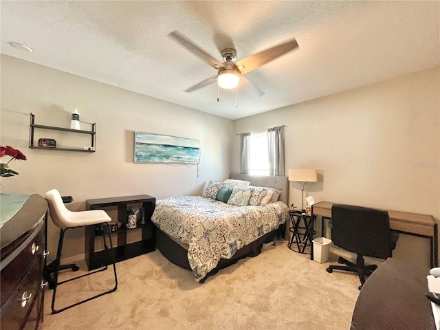 bedroom with ceiling fan, light carpet, and a textured ceiling