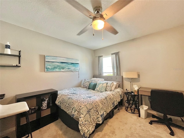 bedroom with ceiling fan, a textured ceiling, and light colored carpet