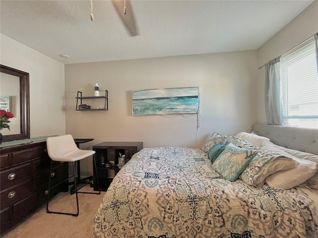 bedroom featuring light carpet and a textured ceiling