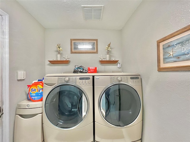 clothes washing area featuring a textured ceiling and separate washer and dryer