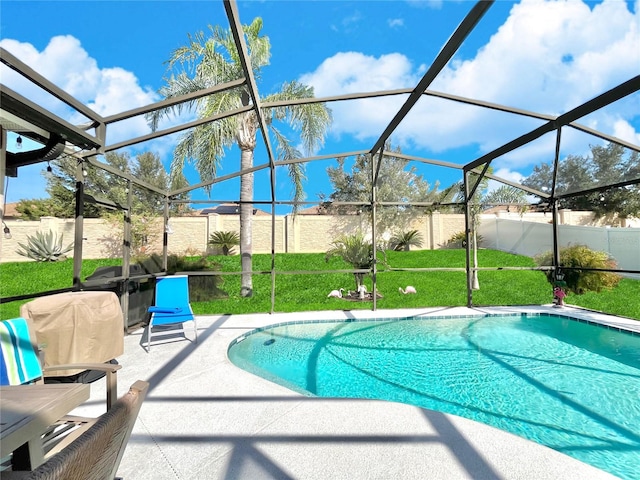 view of swimming pool featuring a yard, a patio area, and glass enclosure