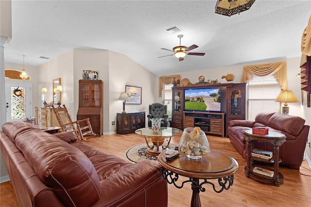 living room with lofted ceiling, light hardwood / wood-style flooring, and plenty of natural light