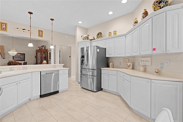 kitchen with pendant lighting, white cabinetry, a notable chandelier, and stainless steel appliances