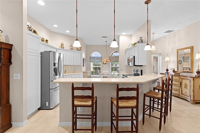 kitchen with appliances with stainless steel finishes, a breakfast bar, pendant lighting, and white cabinets