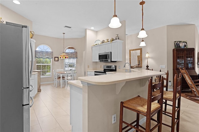 kitchen featuring appliances with stainless steel finishes, hanging light fixtures, white cabinets, and kitchen peninsula