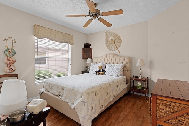 bedroom with a textured ceiling, dark wood-type flooring, and ceiling fan