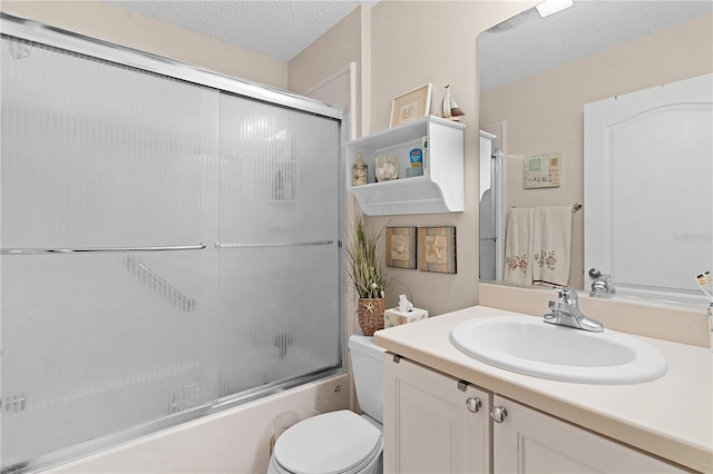 full bathroom featuring vanity, a textured ceiling, shower / bath combination with glass door, and toilet