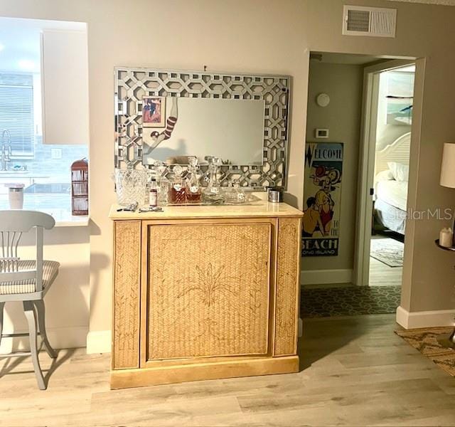 bar with sink and light wood-type flooring