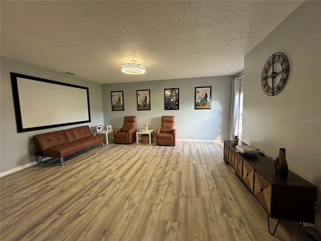 sitting room with light hardwood / wood-style floors and a textured ceiling