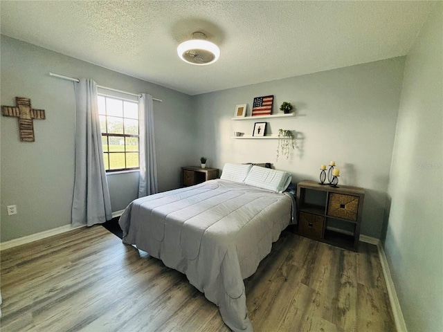 bedroom featuring hardwood / wood-style floors and a textured ceiling