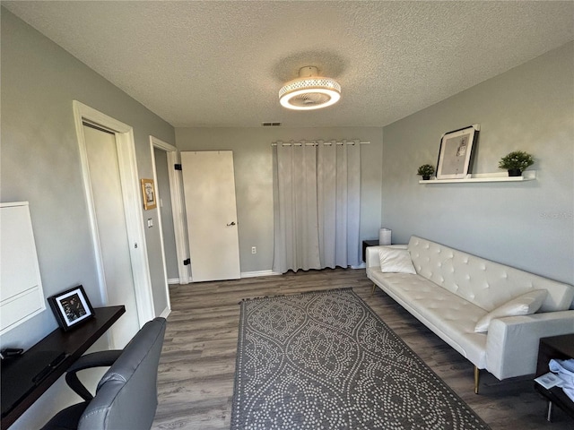 living room with a textured ceiling and hardwood / wood-style floors