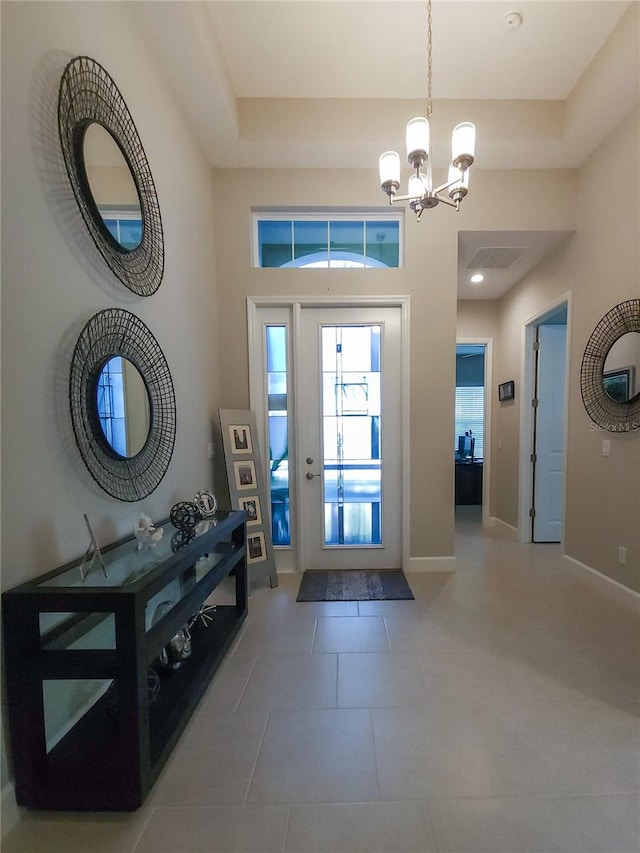 tiled foyer entrance featuring a chandelier