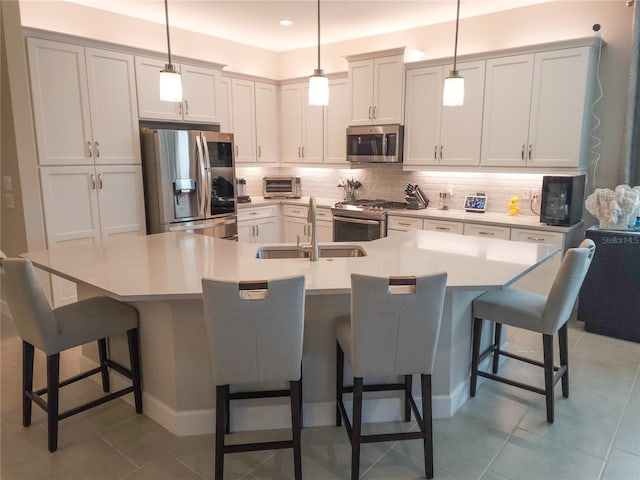 kitchen with a breakfast bar, stainless steel appliances, and pendant lighting