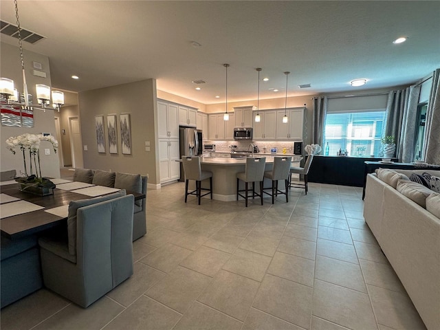 dining space featuring sink, light tile patterned flooring, and an inviting chandelier