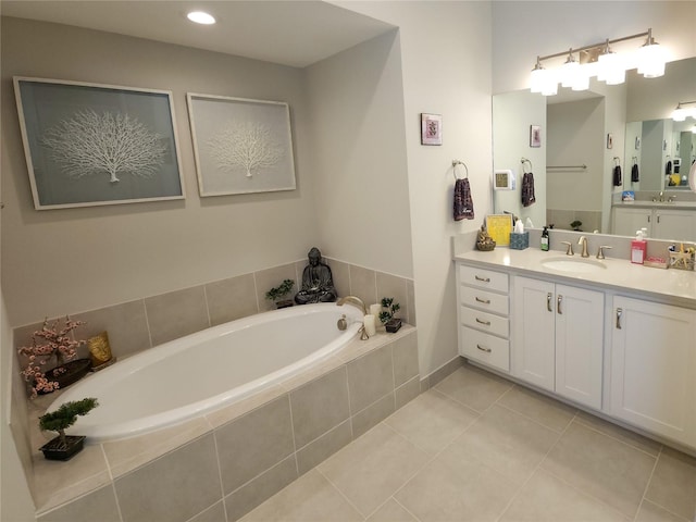 bathroom featuring vanity, tile patterned flooring, and tiled tub