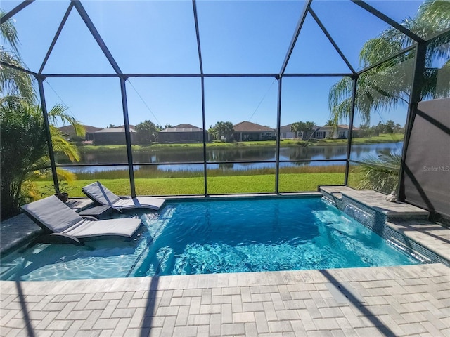 view of pool with a yard, a water view, pool water feature, a patio, and glass enclosure