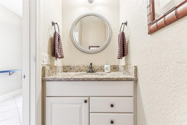 bathroom featuring a textured wall, vanity, and tile patterned floors