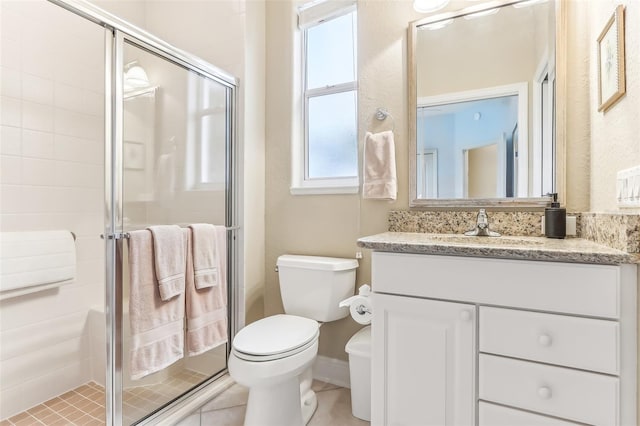 full bathroom with a stall shower, vanity, toilet, and tile patterned floors