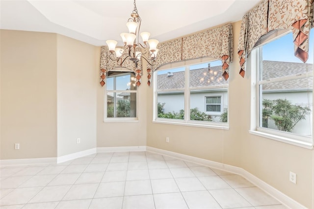 empty room with an inviting chandelier, baseboards, and tile patterned floors